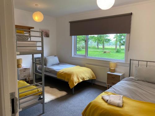 a bedroom with two bunk beds and a window at The Bunkhouse in Applecross