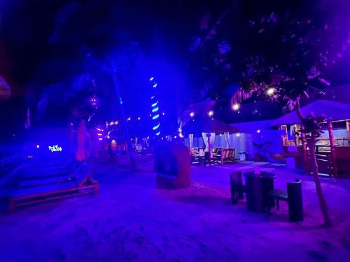 una scena notturna di una spiaggia con luci viola di The Philip Ann Resort a Mabini