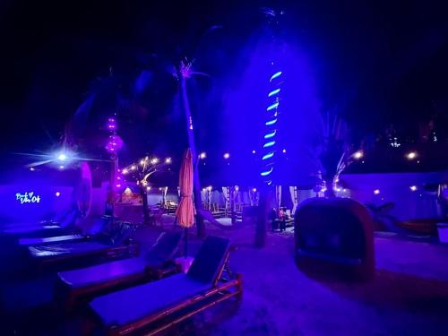 a nightclub with purple lights and chairs and tables at The Philip Ann Resort in Mabini
