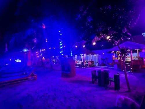 a beach at night with blue and purple lights at The Philip Ann Resort in Mabini