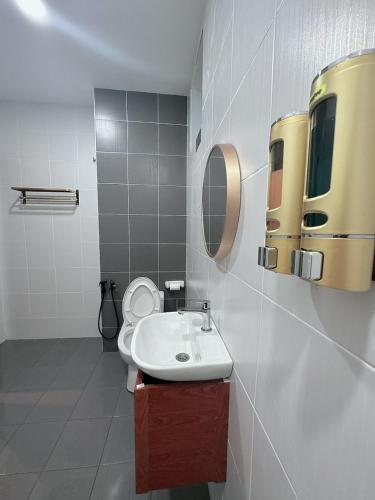 a bathroom with a toilet and a sink and a mirror at The Ambiance, Melaka in Melaka