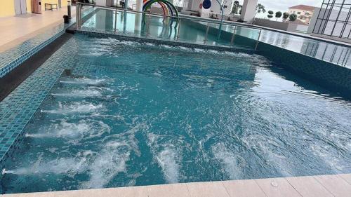 a swimming pool with blue water in a building at The Ambiance, Melaka in Melaka