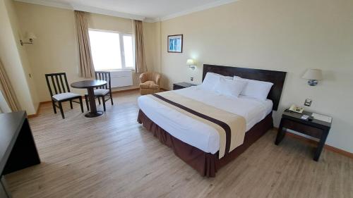 a hotel room with a bed and a table and chairs at Hotel Diego De Almagro Arica in Arica