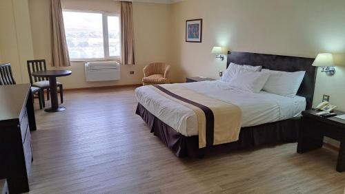 a hotel room with a bed and a table and chairs at Hotel Diego De Almagro Arica in Arica