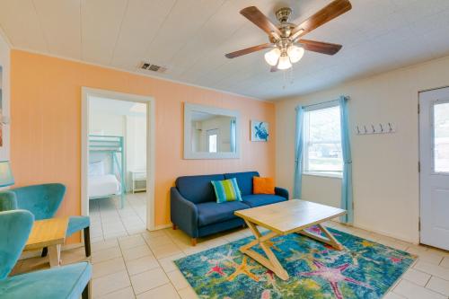 sala de estar con sofá azul y ventilador de techo en Beautiful Rockport Home - Walk to Aransas Bay! en Rockport