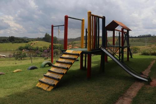a playground with a ladder and a slide at Hotel Fazenda da Lagoa in Queluzita