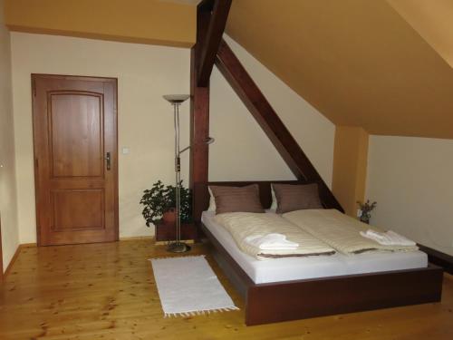Bett in einem Zimmer mit Holzboden in der Unterkunft Dům U Jelena in Vimperk