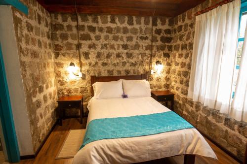 a bedroom with a bed and two tables and a window at Niebli Historical Farm and Lodge at Pululahua Volcano in Quito