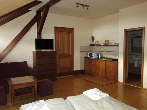 a living room with a couch and a tv and a kitchen at Dům U Jelena in Vimperk