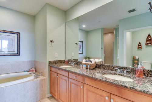 a bathroom with two sinks and a bath tub and a tubermott at Coastal Condo with Harbor Views Steps to Beach! in Clearwater Beach
