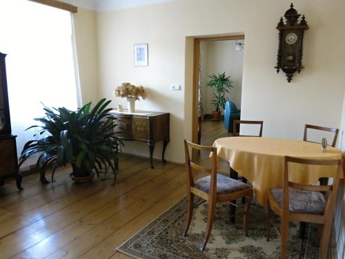 a dining room with a table and chairs and a clock at Dům U Jelena in Vimperk