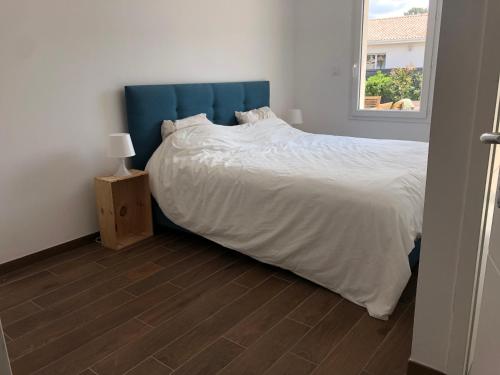 une chambre avec un grand lit avec une tête de lit bleue dans l'établissement Pavillon au bord de l'océan, à Vensac