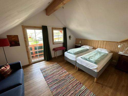 a bedroom with a bed and a blue couch at VillaVoigt, een Gezellig Familiehuis in Äussere Kainisch