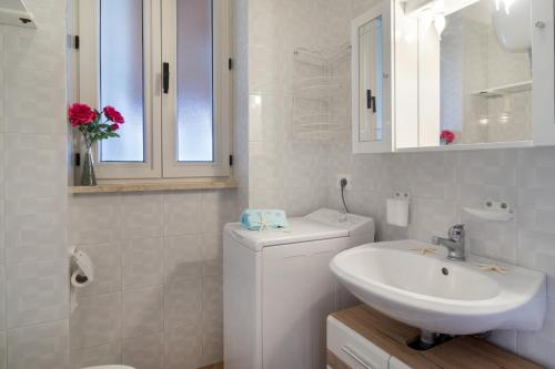 bagno bianco con lavandino e servizi igienici di Appartamento Levante Deluxe pt - MyHo Casa a Torre Canne