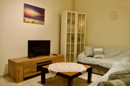 a living room with a flat screen tv and a couch at Vasiliki's Apartment in Psakoudia