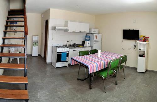 a kitchen with a table and chairs and a kitchen with a stove at Dptos CerBo in Deán Funes