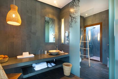 a bathroom with a sink and a glass shower at Tierra Atacama in San Pedro de Atacama