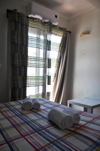 a bedroom with a bed with towels on it at Alojamentos Vitinho - Vila Nova Milfontes in Vila Nova de Milfontes