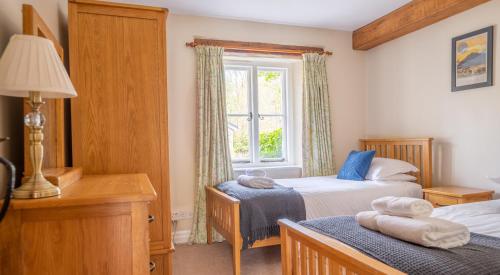 a bedroom with two beds and a window at Bassicks at the Graythwaite Estate in Ulverston