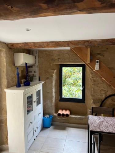 Cette chambre comprend une armoire blanche et une fenêtre. dans l'établissement La terrasse de Caromb face au Mont VENTOUX maison avec clim, à Caromb