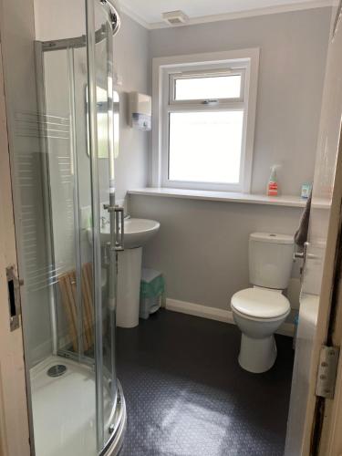 een badkamer met een toilet, een wastafel en een raam bij The Bunkhouse in Applecross