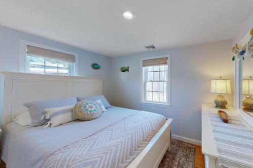um quarto com uma cama com paredes e janelas azuis em Downtown Beach Cottage em West Yarmouth