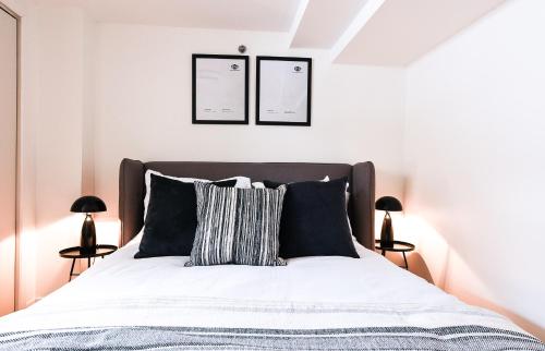 a bedroom with a bed with white sheets and two lamps at Amazing Location in Old Quebec - 1br Condo in Quebec City
