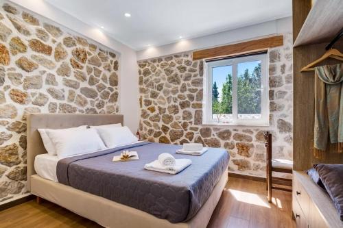 1 dormitorio con cama y pared de piedra en Sea view apartments, en Tsoukaladhes