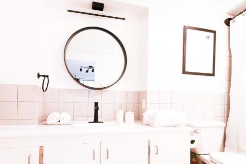 a white bathroom with a mirror and a sink at Amazing Location in Old Quebec - 1br Condo in Quebec City
