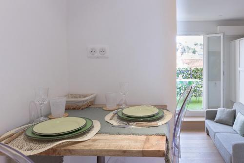 una mesa de comedor con platos verdes. en Un Écrin au Suquet - Studio, clim, balcon, plage, Palais des Festivals en Cannes