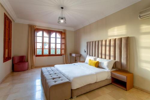 una camera con un grande letto con una panca accanto di Villa Luxe a Marrakech