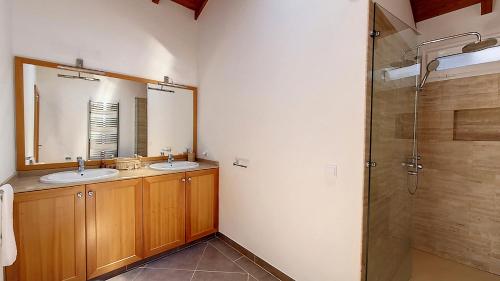 a bathroom with two sinks and a shower at Bohome Nest by LovelyStay in Arco da Calheta