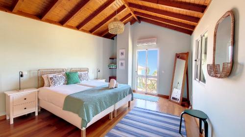 a bedroom with a bed and a large window at Bohome Nest by LovelyStay in Arco da Calheta