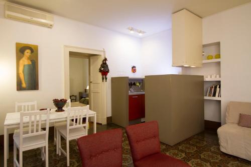 cocina y sala de estar con mesa y sillas. en Tre Vie apARTment con terrazzo giardino pensile, en Catania