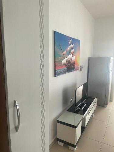 Habitación con escritorio y una pintura en la pared. en apartament, en Durrës