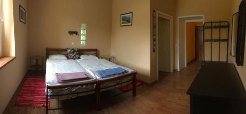 Un dormitorio con una cama con sábanas blancas. en Tatanya Panzió, en Tata