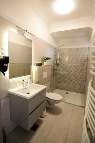 a bathroom with a sink and a toilet and a shower at Markó Vendégház in Kiskőrös