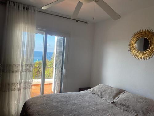 1 dormitorio con cama y ventana con vistas al océano en Inga´s Apartment, en Alaior