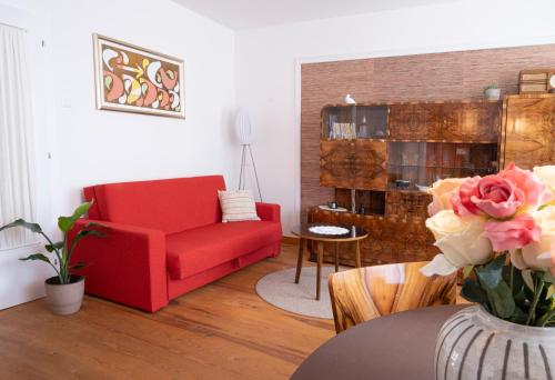 a living room with a red chair and a table at Passero Holiday House in Moravske-Toplice