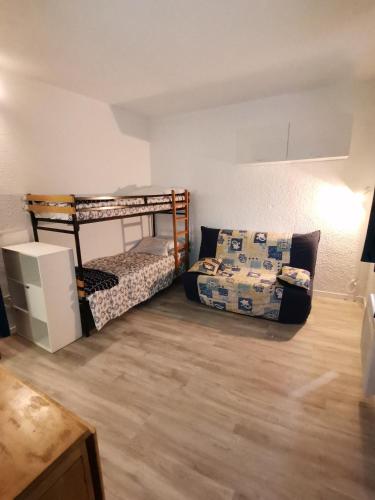 a room with two bunk beds and a couch at STUDIO LES GLOVETTES in Villard-de-Lans