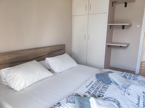 a bed with two pillows and two towels on it at Golden Sky 1 Apartment in Perea