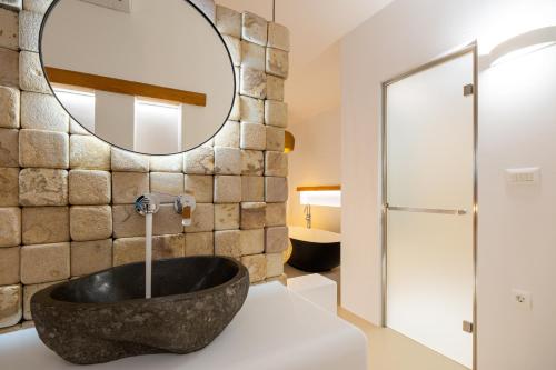 a bathroom with a large stone sink and a mirror at Utopia Suites by Anna Platanou in Agia Irini Paros