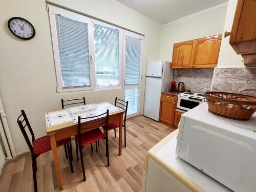 a kitchen with a table and chairs and a refrigerator at Апартамент за гости, ж.к. Зорница , бл.9 in Burgas City