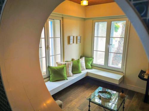 a room with a bench in front of two windows at Garden's Nest - North Villa in Conceição