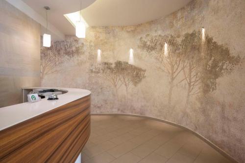a kitchen with a mural of trees on the wall at Hotel La Pineta in Follonica