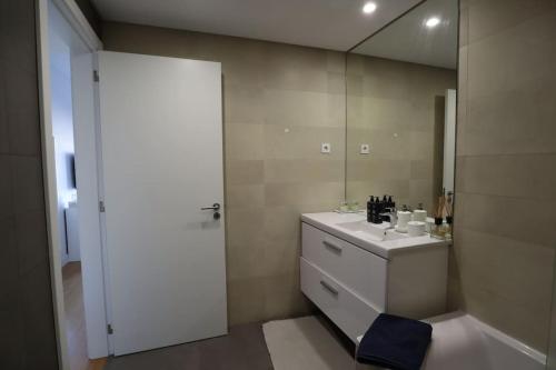 a bathroom with a sink and a mirror at River Terrace & Pool View - Seixal in Seixal
