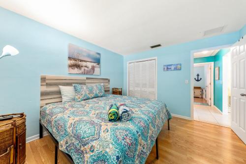 1 dormitorio con 1 cama con paredes azules y suelo de madera en Beach Villa A en Clearwater Beach