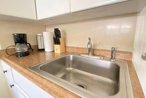 a kitchen counter with a stainless steel sink at Blissful Studio in Hallandale Beach 8mins to beach in Hallandale Beach