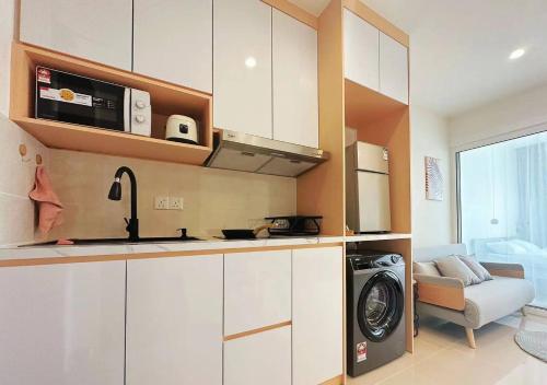 a kitchen with a washer and dryer in a room at Summer Studio Apartment at Kota Kinabalu City Centre in Kota Kinabalu
