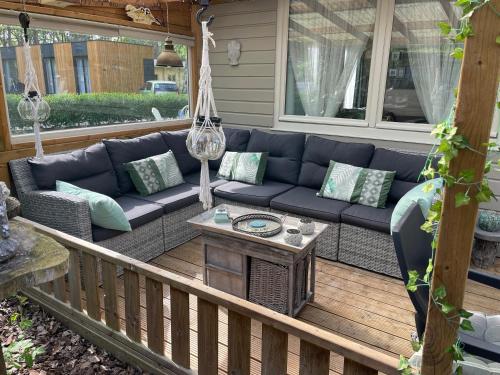 a porch with a blue couch and a table at Chalet Sint-Hubertus in Zutendaal